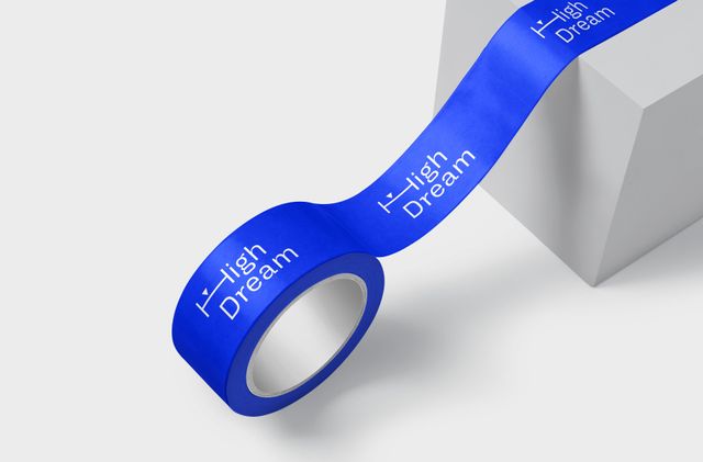 Selbst das Paketband wird zur Bühne für die Markenidentität. Leicht abgerolltes Paketband mit dem weißen Logo auf blauem Hintergrund.