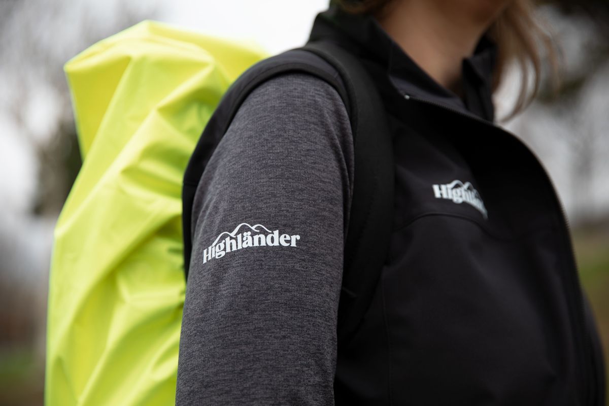 Gedrucktes Logo auf dem Ärmel eines Funktionsshirts und der Brust einer Outdoor-Weste.