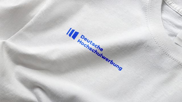 Gedrucktes Logo der Deutschen Hochschulwerbung auf einem weißen T-Shirt.