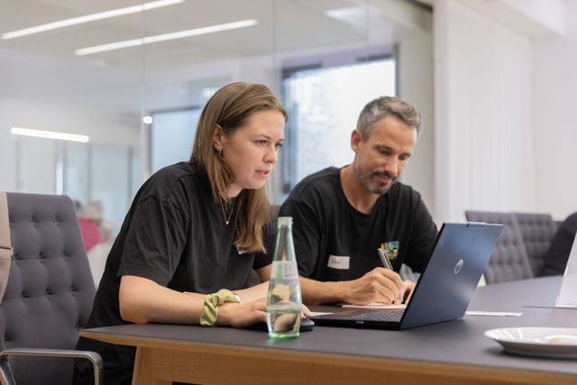 Gemeinsame UX-Analyse im Workshop unterstützt fundierte Entscheidungen, kollaborative Produktentwicklung und eine bessere User Experience. Zwei Teilnehmende analysieren gemeinsam digitale Konzepte am Laptop und entwickeln im UX-Workshop nutzerzentrierte Lösungsansätze.