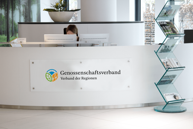 Im Empfangsbereich des Genossenschaftsverbandes ist das neue Logo groß auf einem Acrylschild abgebildet