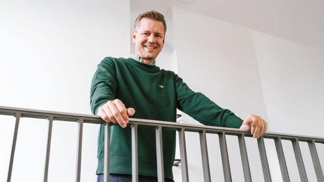 Mann steht gelehnt an ein Treppengeländer.