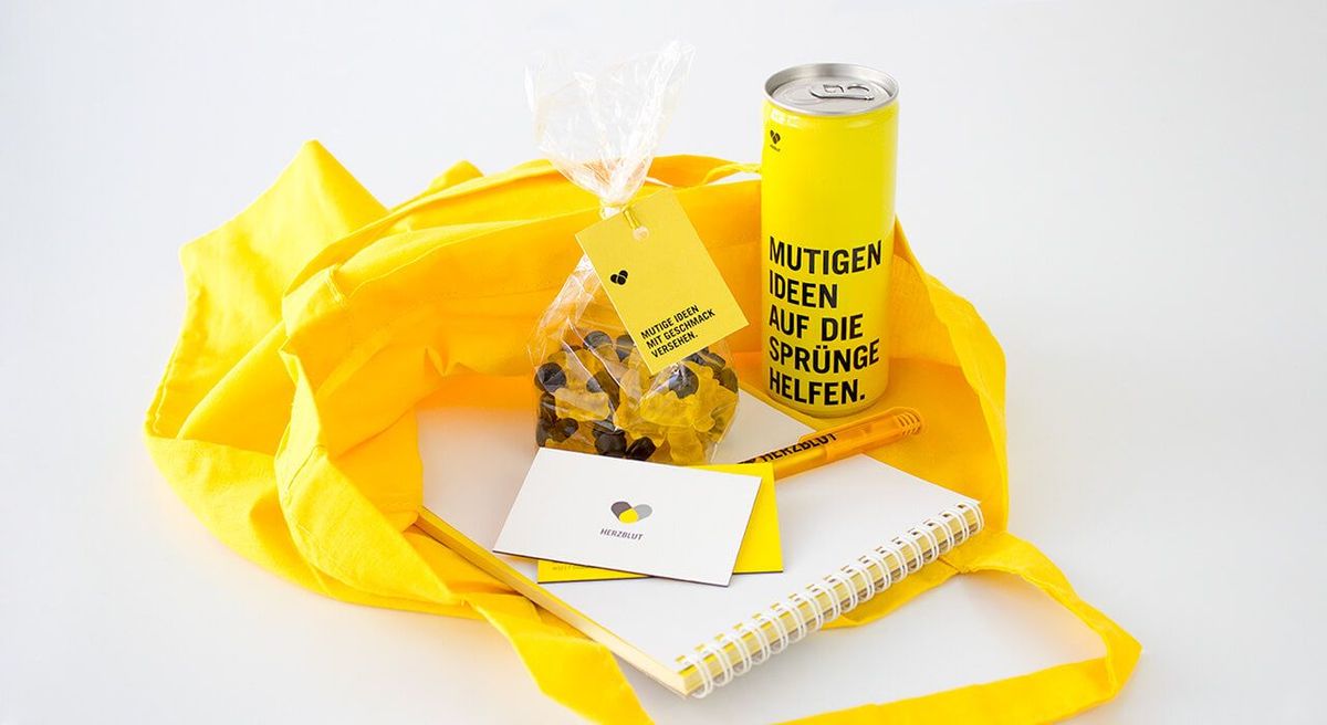 Innenansicht in den Goodiebag der Herzblut Unternehmensberatung (Energydrink-Dose, Gummibärchen-Tüte, Stift, Schreibblock, Visitenkarte)
