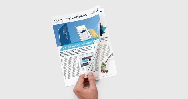 Eine Hand blättert im Magazin für Royal Fishing
