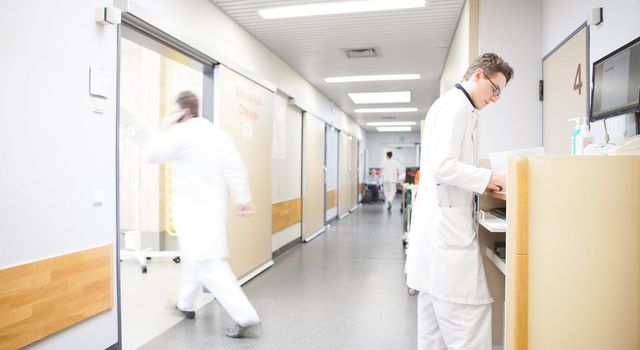 Flur eines Krankenhauses auf dem sich mehrere Mitarbeiter befinden