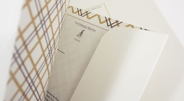 Halb aufgeschlagene Dokumentenmappe mit innenliegendem Briefbogen von Thomas Rath Trousers