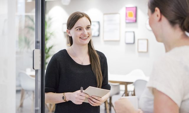 Die neue Mitarbeiterin Christina unterhält sich mit einer Kollegin