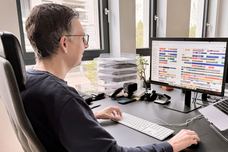 Jan Teunissen sitz am Schreibtisch. Auf einem Monitor ist eine Projektplanung zu sehen.