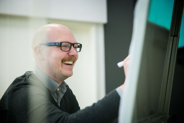 Daniel Urban mit lachendem Gesichtsausdruck schreibt an's Flipboard