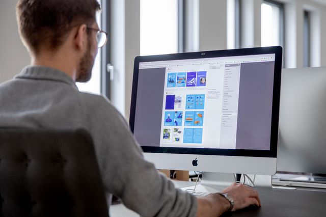 Junior Art Director arbeitet am Computer an einem Styleguide im Brand Portal