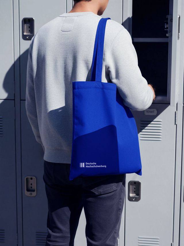 Person trägt eine Stofftasche mit Logo der Deutschen Hochschulwerbung.