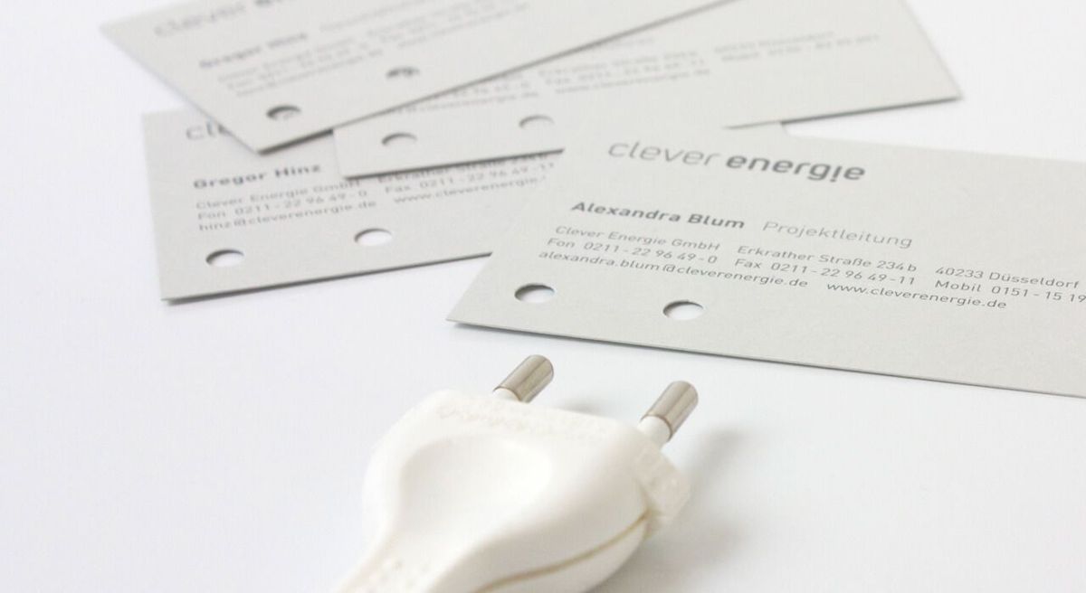 Visitenkarten liegen auf einem Tisch neben einem Stecker