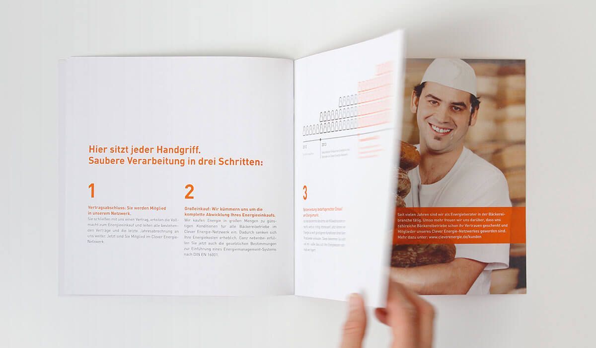 Eine Person blättert in der Imagebroschüre für Clever Energie