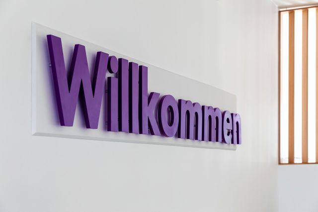 Die Besucher des „Hauses der Kirche“ werden von einem großen Willkommensschriftzug an einer Wand im Foyer begrüßt. Ein großer Willkommensschriftzug an einer Wand im Foyer des „Hauses der Kirche“