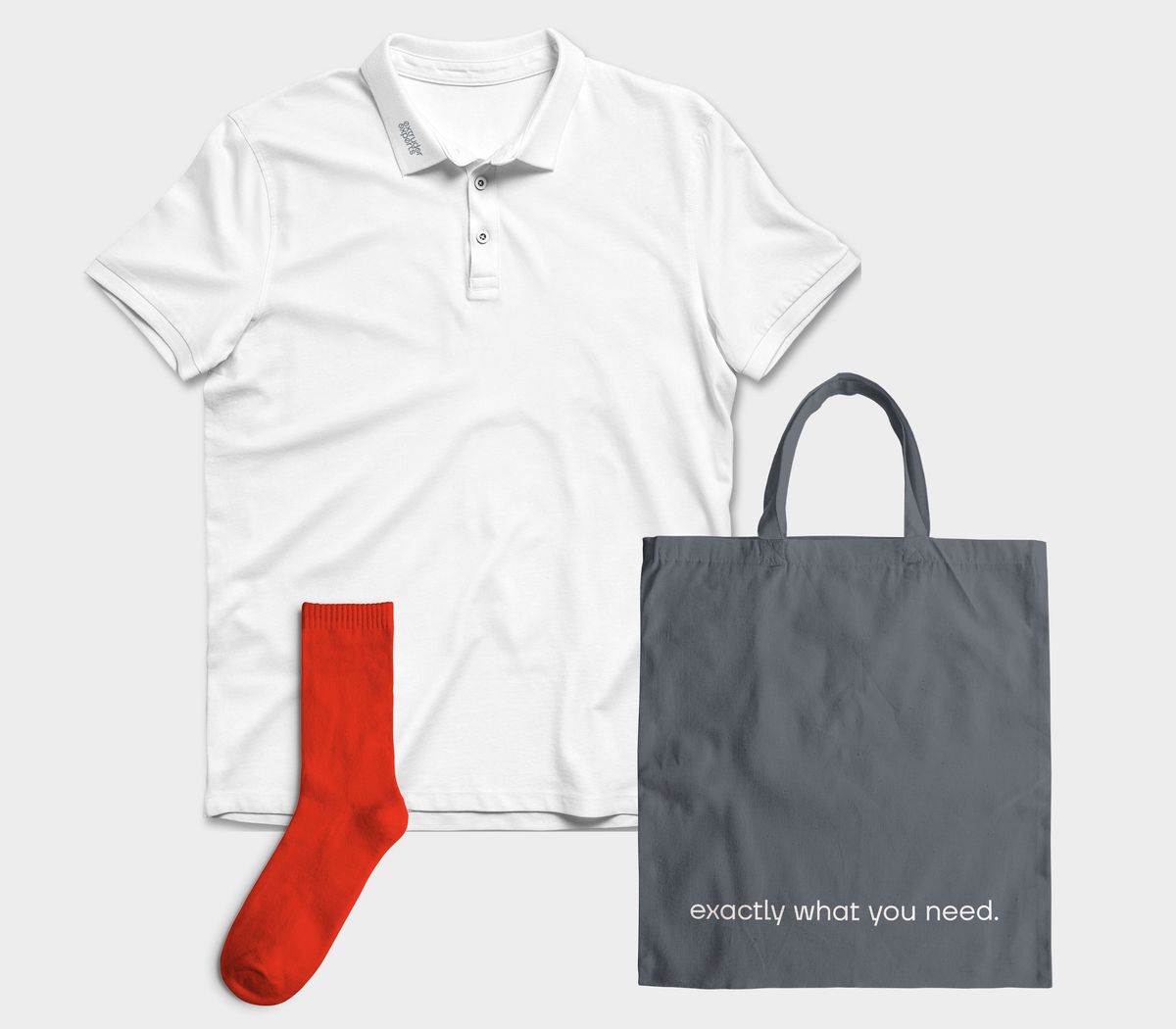 Übersicht der Messekleidung aus einem T-Shirt mit besticktem Logo, einer dunklegrauen Tasche mit dem Claim und roten Socken