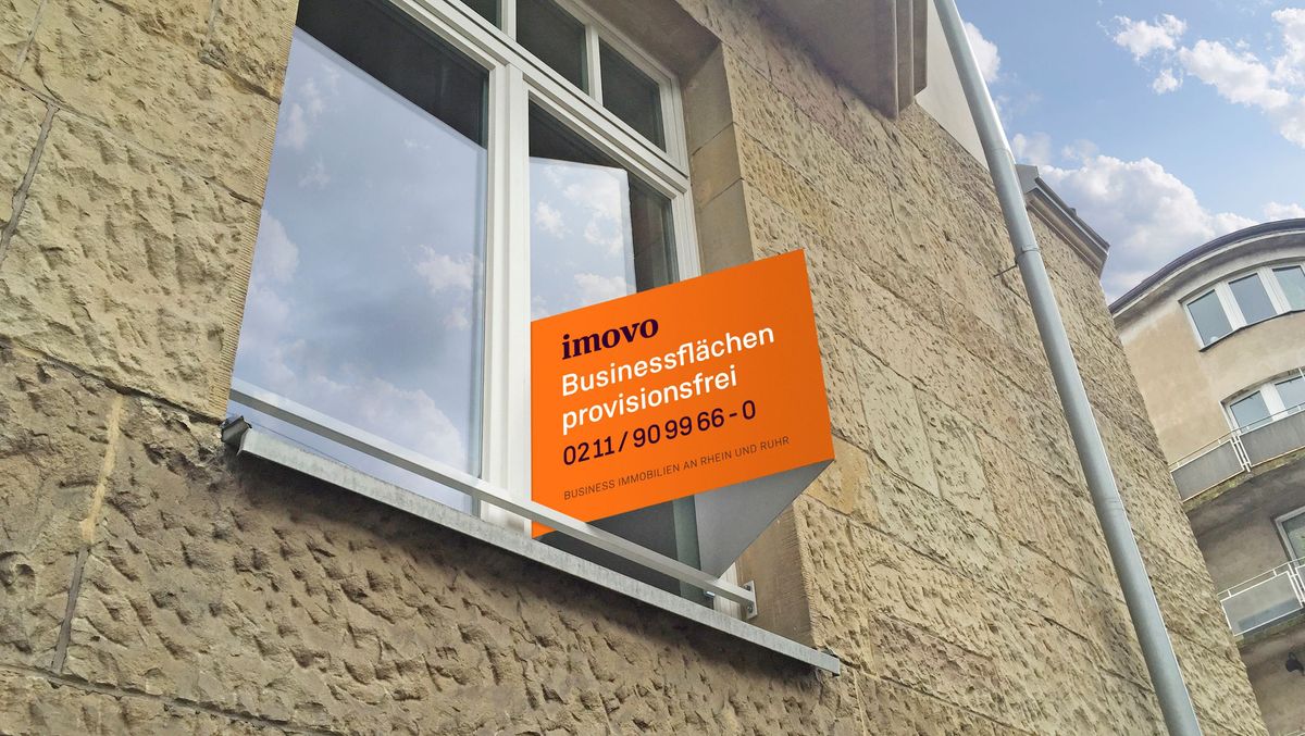 Ein Nasenschild von imovo an der Außenfassade eines Gebäudes