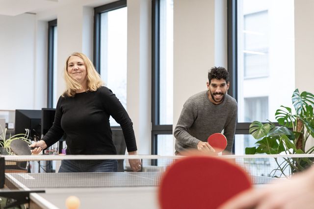 Mitarbeiter der Designagentur arndtteunissen spielen Tischtennis im Büro